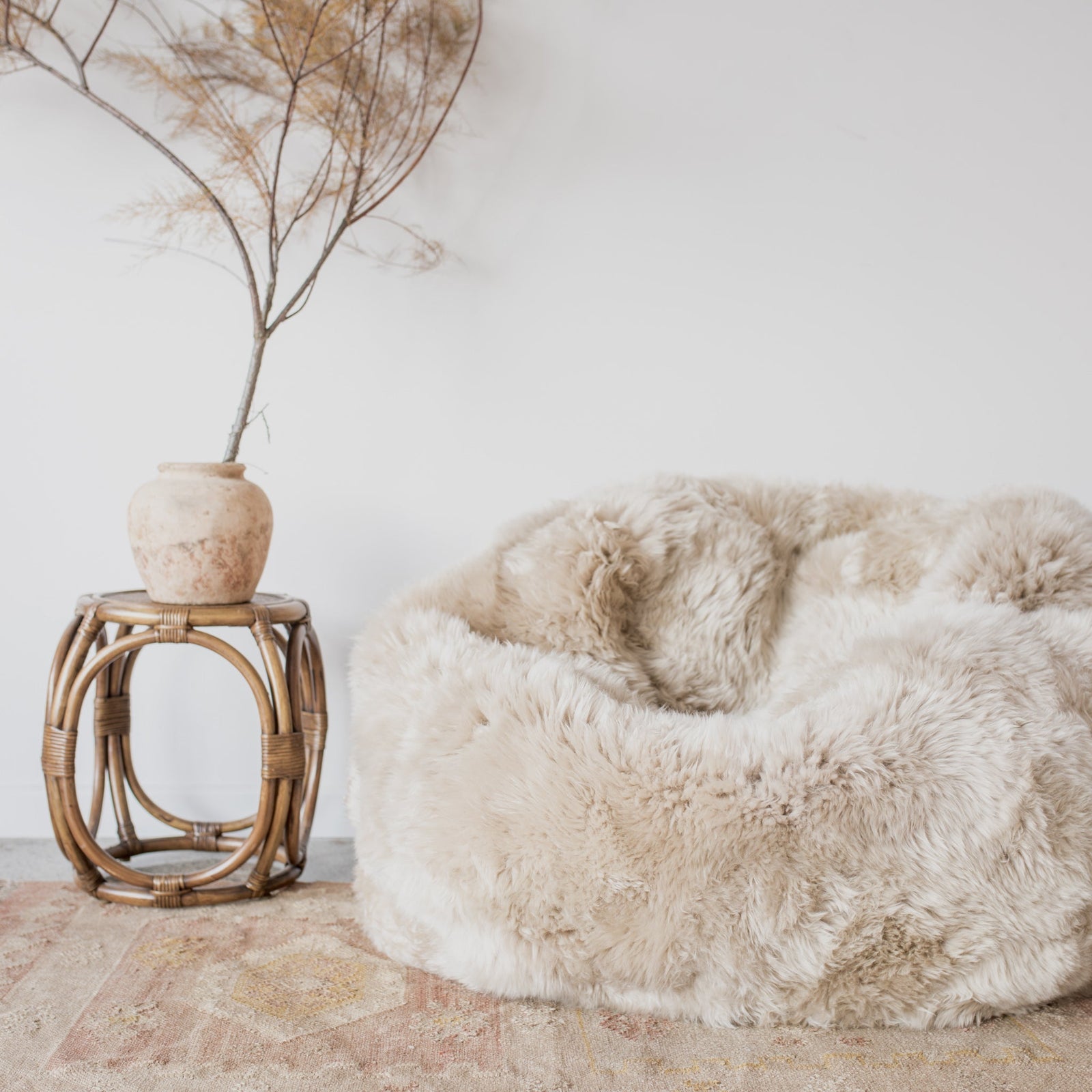 pure wool New Zealand sheepskin bean bag chair  light cream color with small rattan side table
