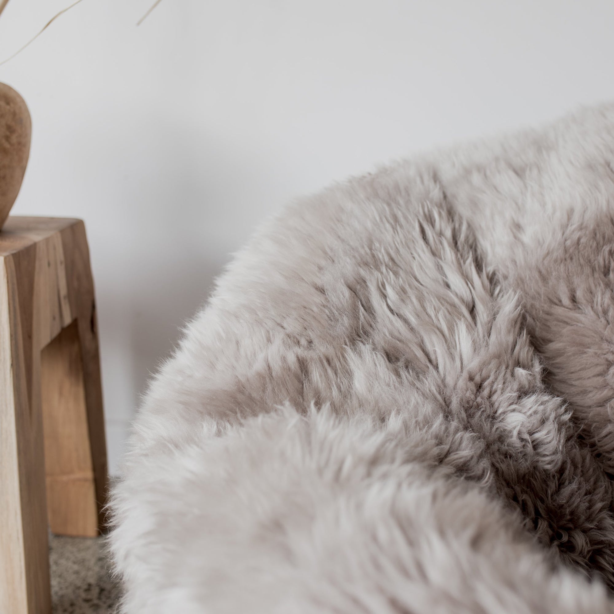 close up of the pure wool New Zealand sheepskin bean bag chair in a light gray color