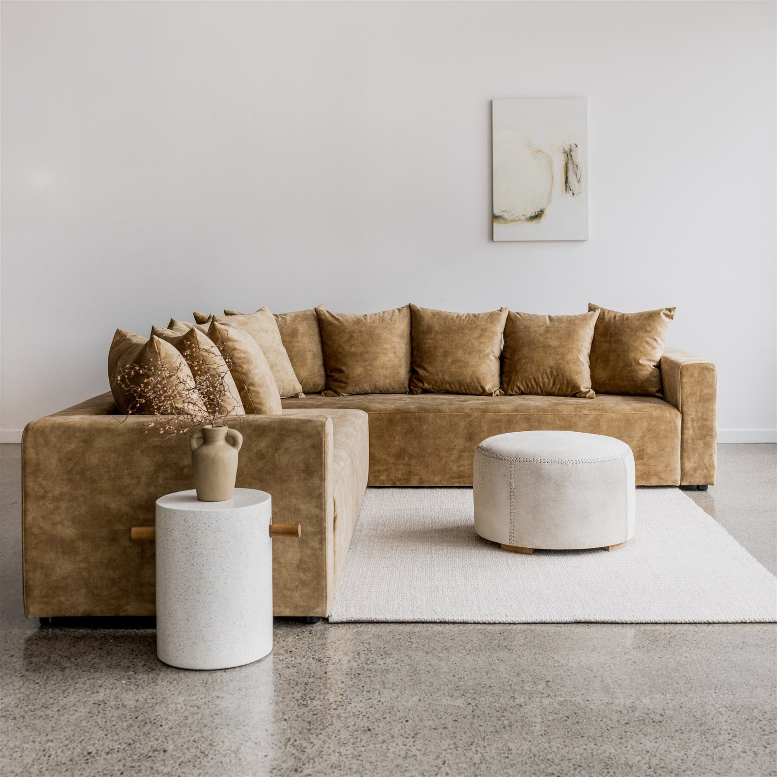 modern round hair on hide ottoman coffee table from corcovado design online in front of a corner sofa